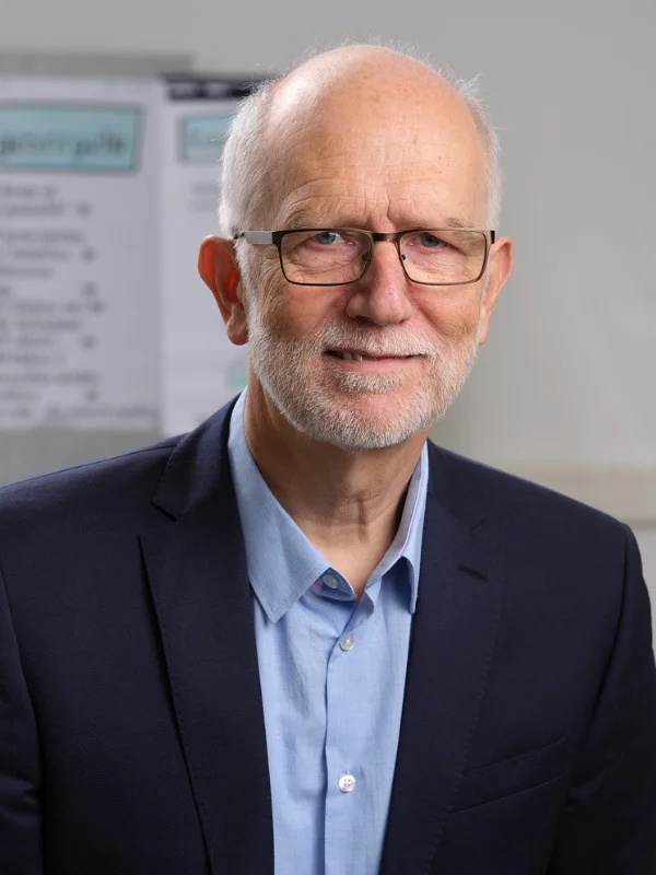 Porträt eines lächelnden Beraters im Anzug im Büro - Jürgen Rüst der als Ansprechpartner für Beratung und Fragen zur Verfügung steht.